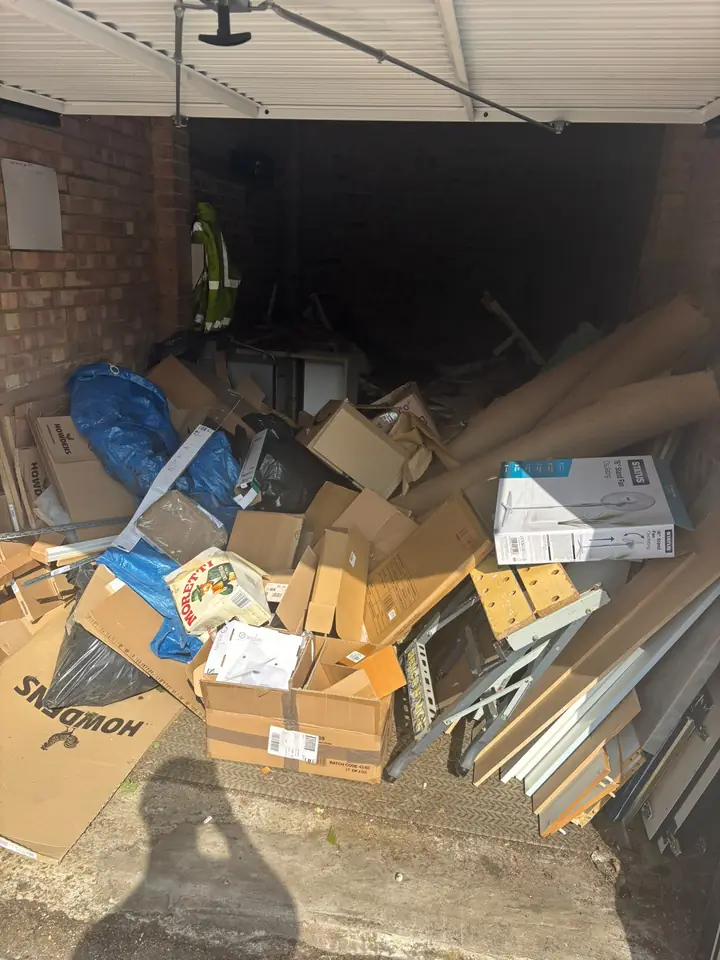 Cardboard, bags and loose contents filling a garage.